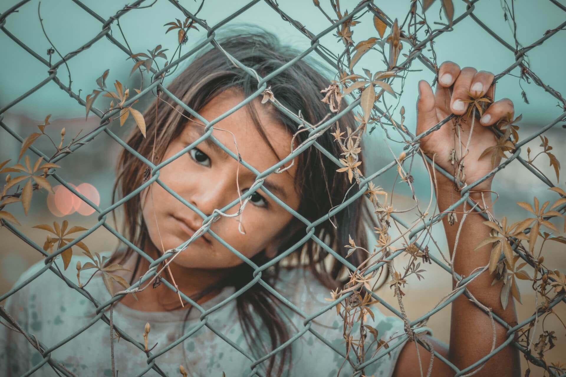 Girl S White And Gray Crew Neck Top Holding Gray Wire Fence 1098769